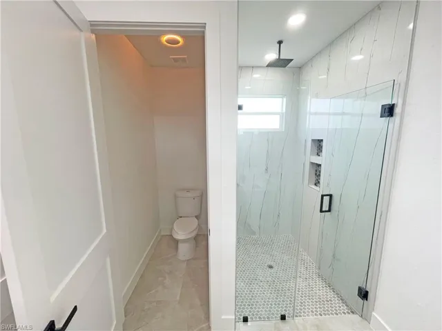 Bathroom with toilet and a shower with shower door