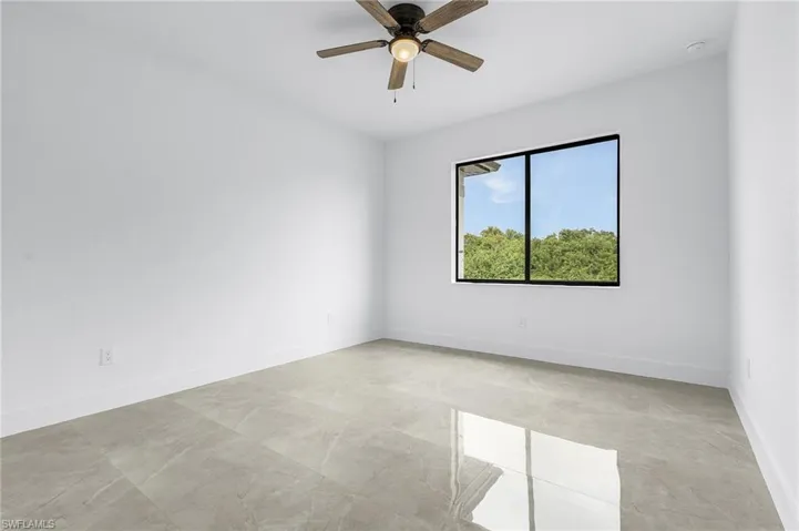 Tiled empty room featuring ceiling fan