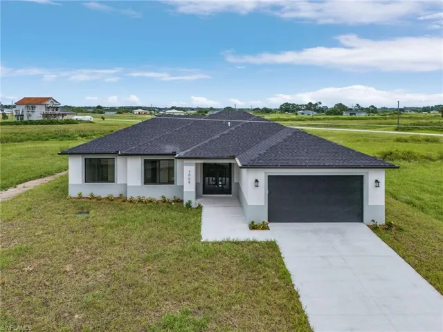 Single story home featuring a garage and a front yard
