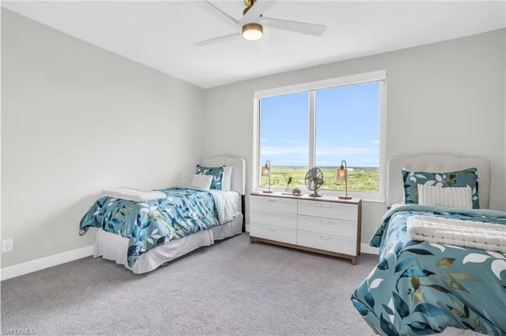 Carpeted bedroom featuring ceiling fan
