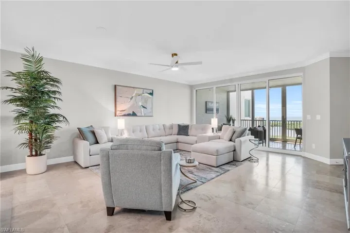 Living room featuring crown molding, light tile patterned floors, and ceiling fan
