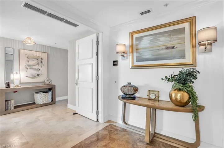 Hallway featuring ornamental molding and light tile patterned floors