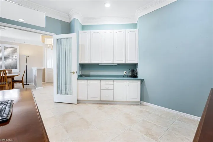 Kitchen featuring ornamental molding, white cabinets, and light tile patterned floors