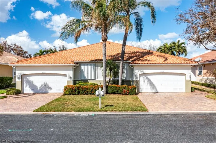 View of front of home with a garage and a front lawn