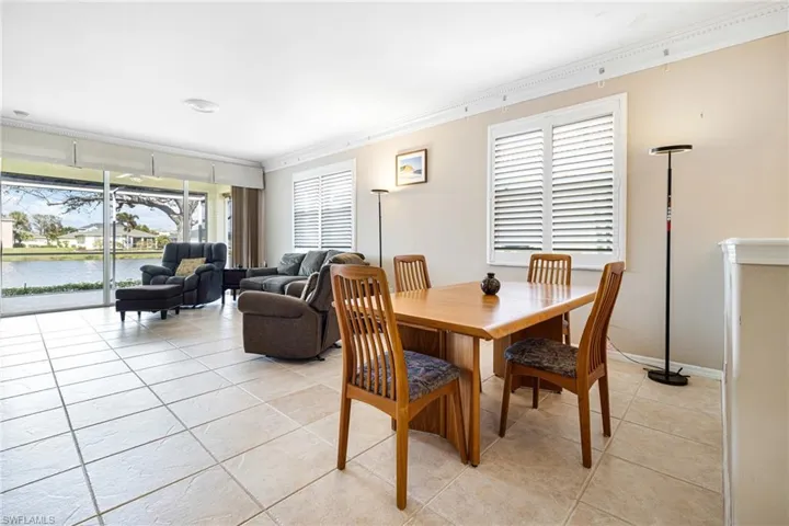 Dining space featuring ornamental molding, a water view, and light tile patterned floors