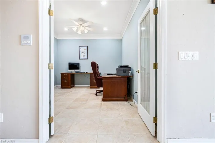 Tiled office space featuring french doors, crown molding, and ceiling fan