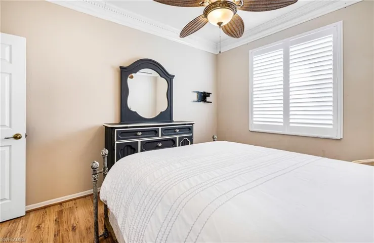 Bedroom featuring ceiling fan, hardwood / wood-style flooring, and ornamental molding