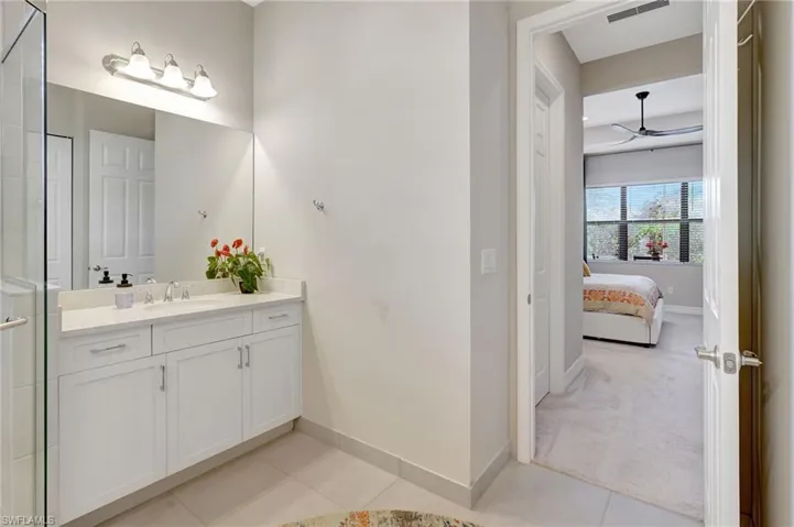 Bathroom with baseboards, ensuite bath, visible vents, and tile patterned floors