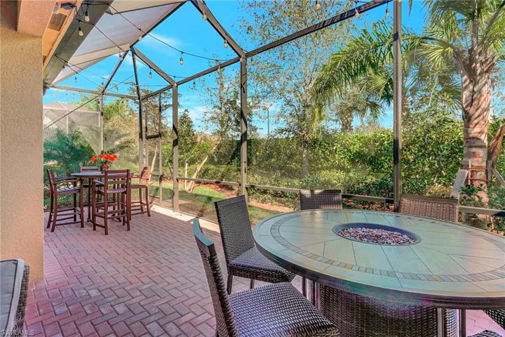 View of patio with outdoor dining space and a lanai