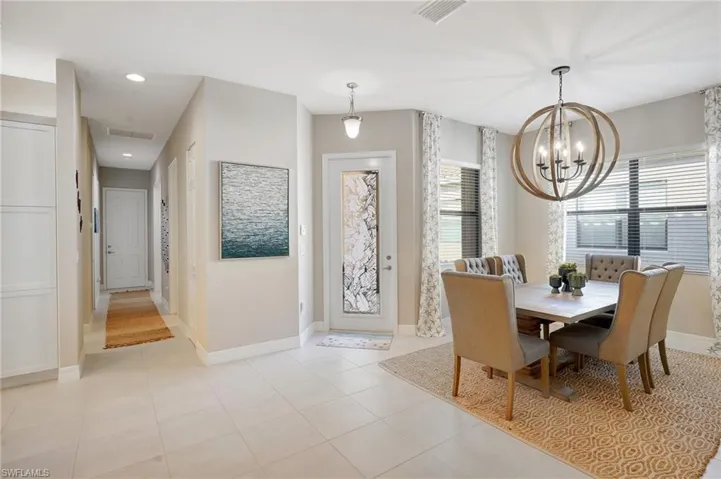 Dining space featuring visible vents, a notable chandelier, baseboards, and light tile patterned floors