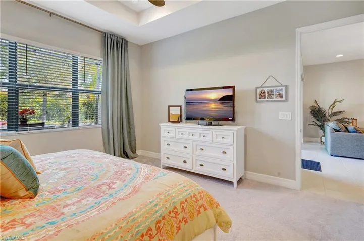 Bedroom with baseboards, light tile patterned floors, and light colored carpet