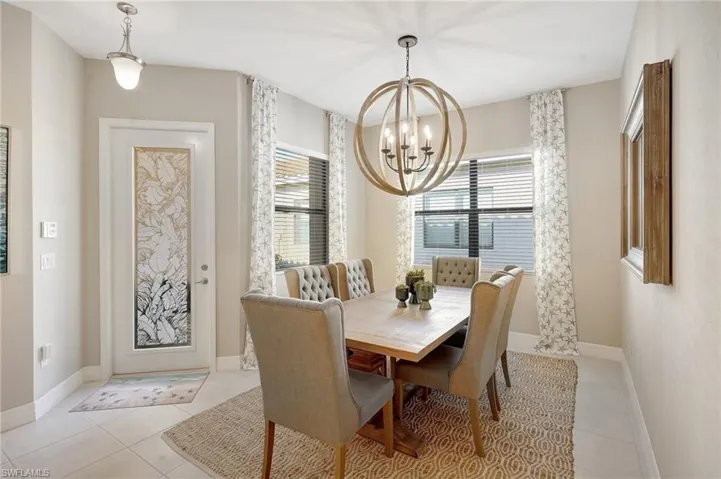 Dining area featuring a chandelier, light tile patterned floors, a wealth of natural light, and baseboards