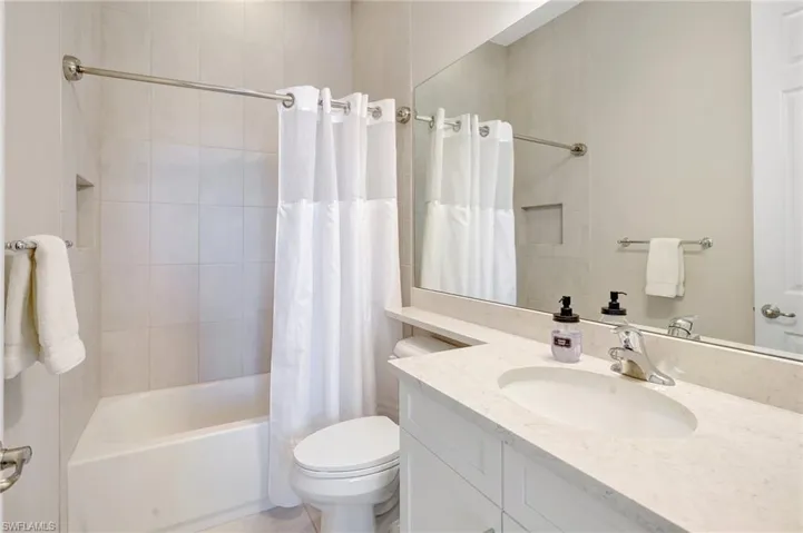 Full bath featuring shower / bath combo, vanity, and toilet