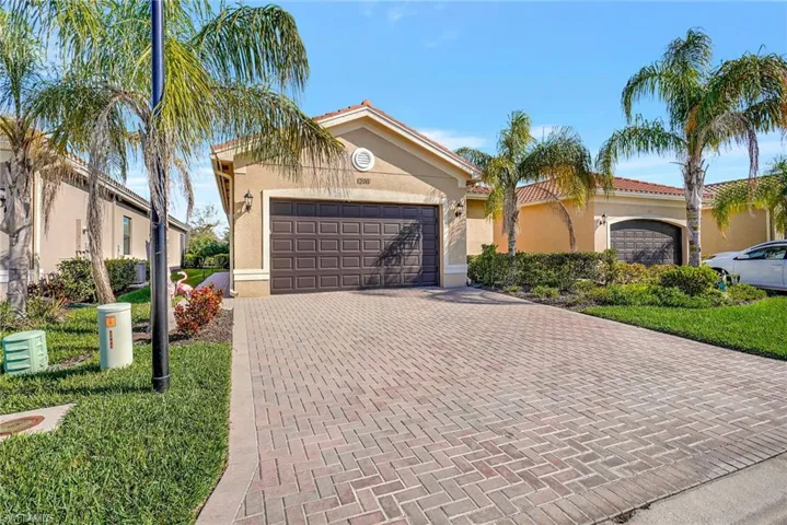 Mediterranean / spanish house with a garage, decorative driveway, and stucco siding