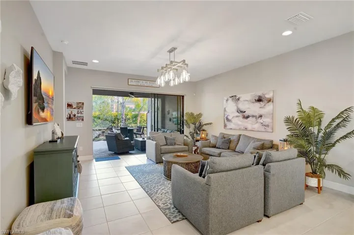 Living room featuring light tile patterned floors, baseboards, visible vents, and recessed lighting