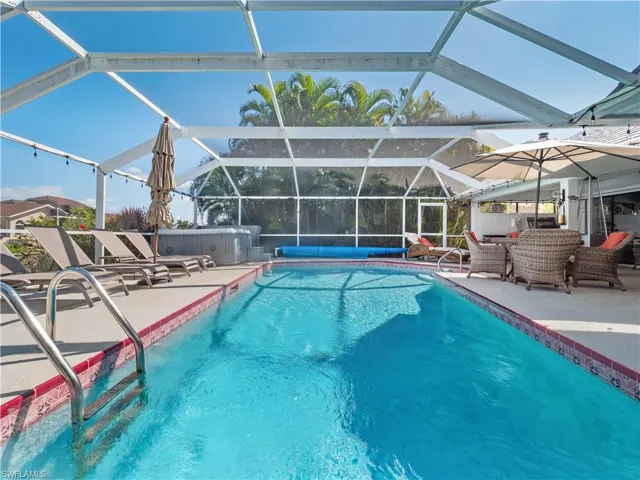 Swimming pool with glass enclosure, a sunroom, and a patio