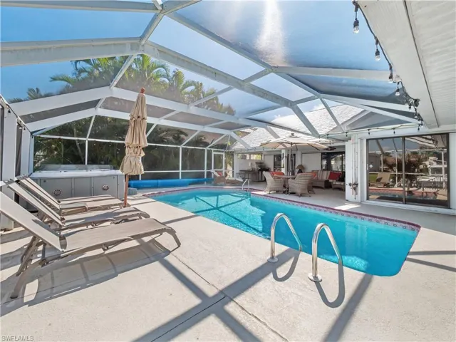 Outdoor pool featuring a patio area, a sunroom, a lanai, and a hot tub