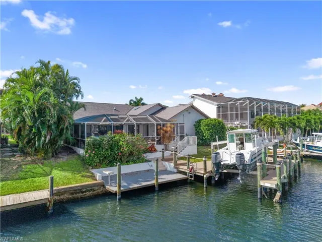 Dock featuring a lanai, a water view, a sunroom, and boat lift