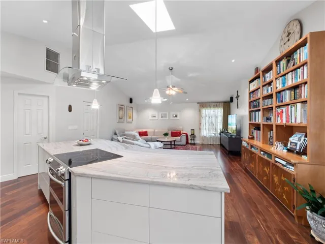 Kitchen with range with two ovens, dark wood finished floors, island range hood, open floor plan, and ceiling fan