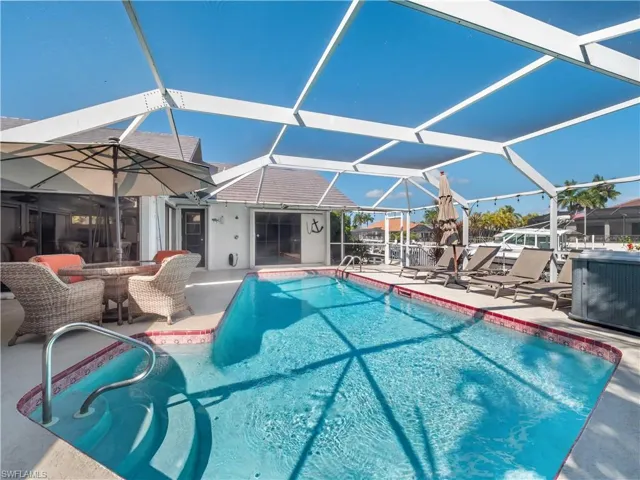 Swimming pool with a sunroom, a patio, glass enclosure, and outdoor dining space