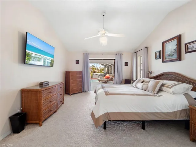 Bedroom with lofted ceiling, access to exterior, light carpet, and ceiling fan