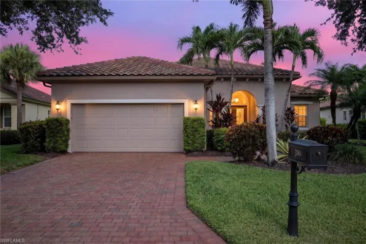 Mediterranean-style residence featuring a barrel tile roof, stucco exterior, and an arched entry