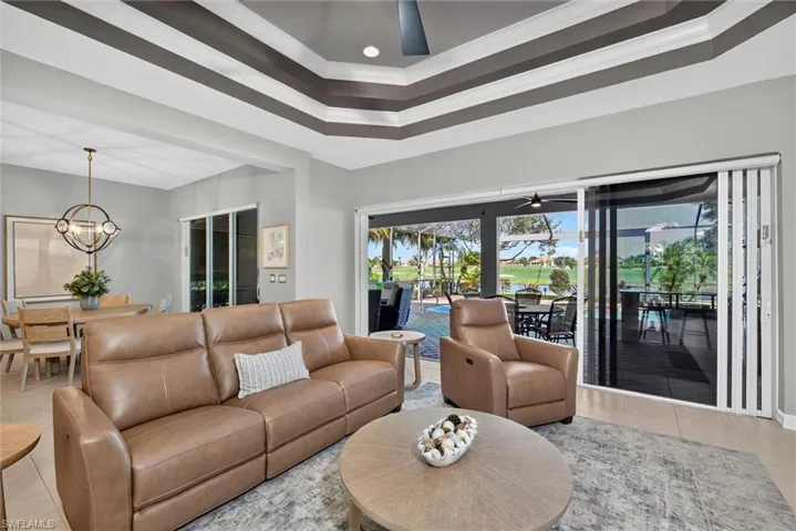 Spacious living area featuring a tray ceiling, recessed lighting, and large sliding glass doors