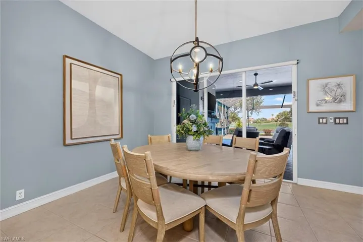 Dining area featuring tile flooring, a contemporary chandelier, and direct access to an outdoor living space via large glass sliders