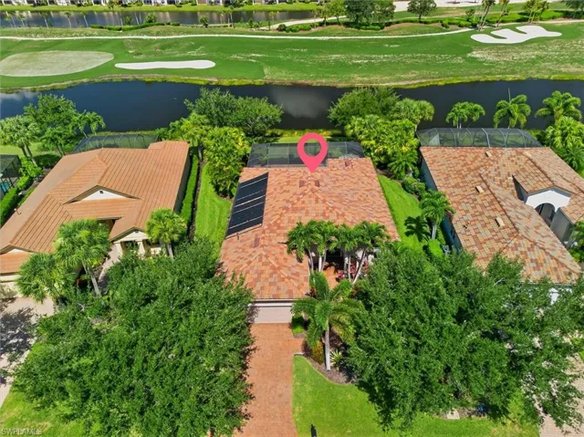 Tile-roof residence with solar panels and a screened-in rear patio, bordered by mature trees and a manicured lawn
