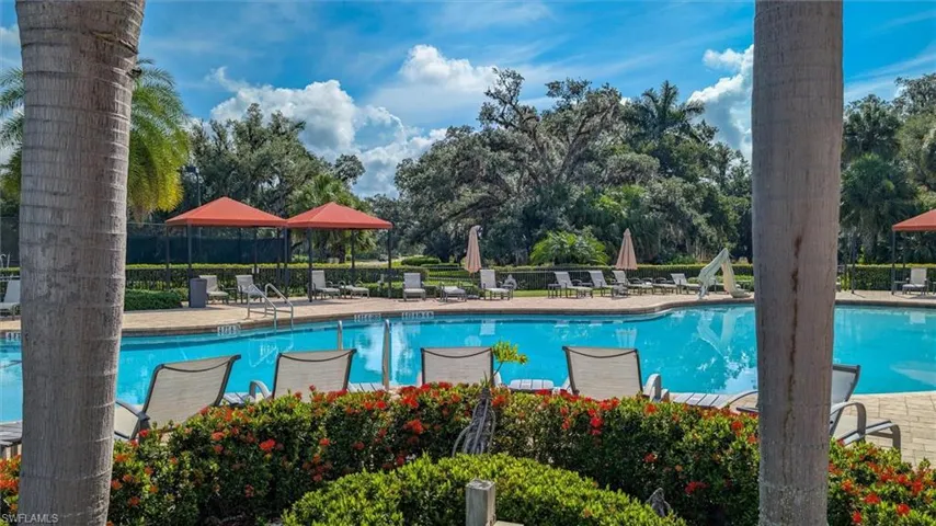 Expansive swimming pool area with paver decking and lush perimeter landscaping