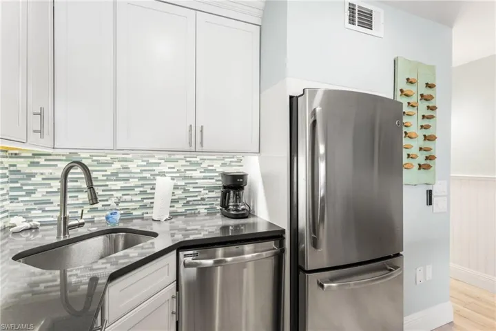 Stainless appliances, custom tile backsplash, soft close white cabinetry.