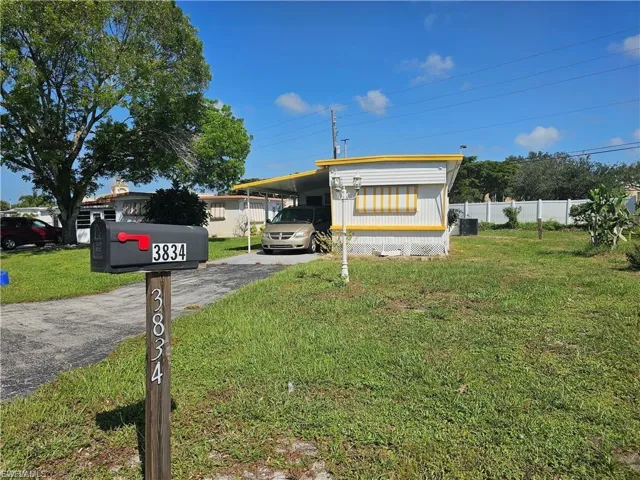 View of front of house with an attached carport and asphalt driveway