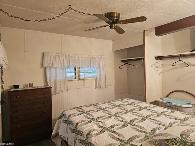 Bedroom featuring ceiling fan and a textured ceiling