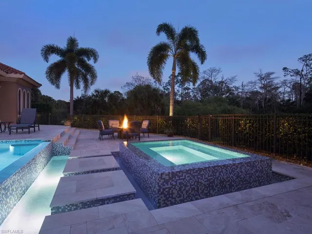 View of pool with an in-ground hot tub, patio surround, an outdoor fire pit, and a fenced backyard