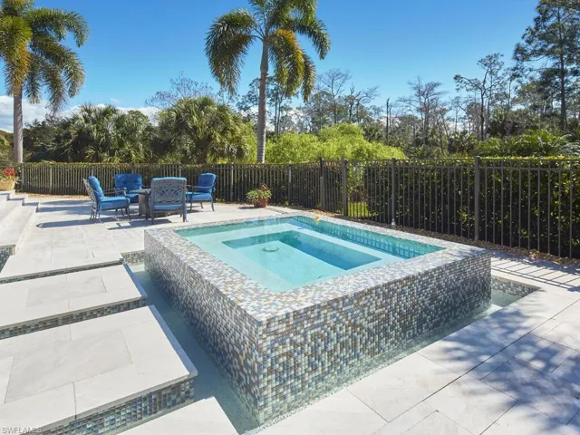 View of swimming pool featuring an in-ground hot tub, patio surround, and a fenced backyard