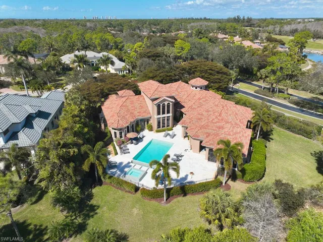 Bird's eye view of a pool area and a tree filled landscape