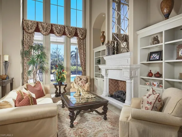 Living room featuring a high ceiling, a fireplace, and built in features