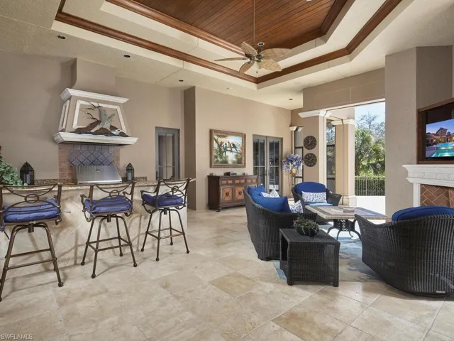 Living area featuring a fireplace, ceiling fan, and a tray ceiling