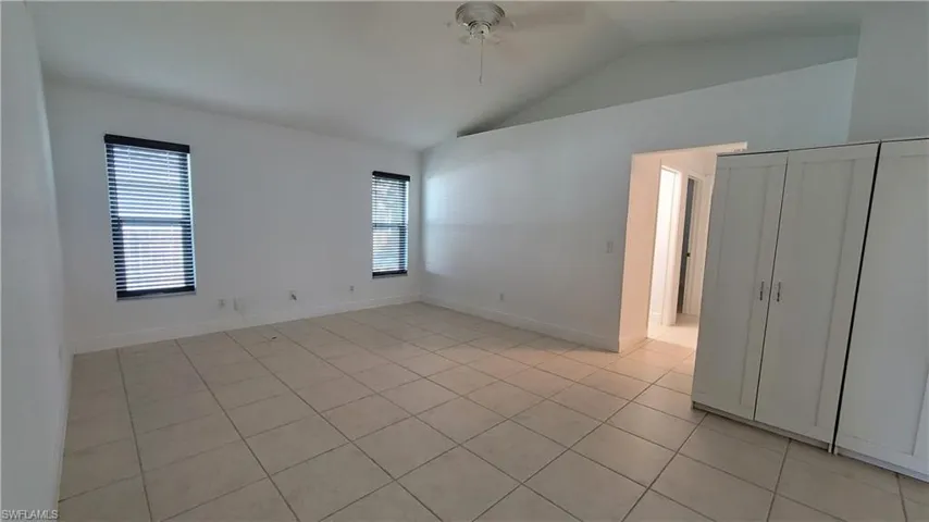 Tiled spare room with plenty of natural light, lofted ceiling, and ceiling fan
