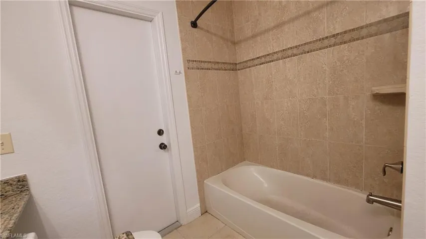 Bathroom featuring vanity, tile patterned floors, and tiled shower / bath