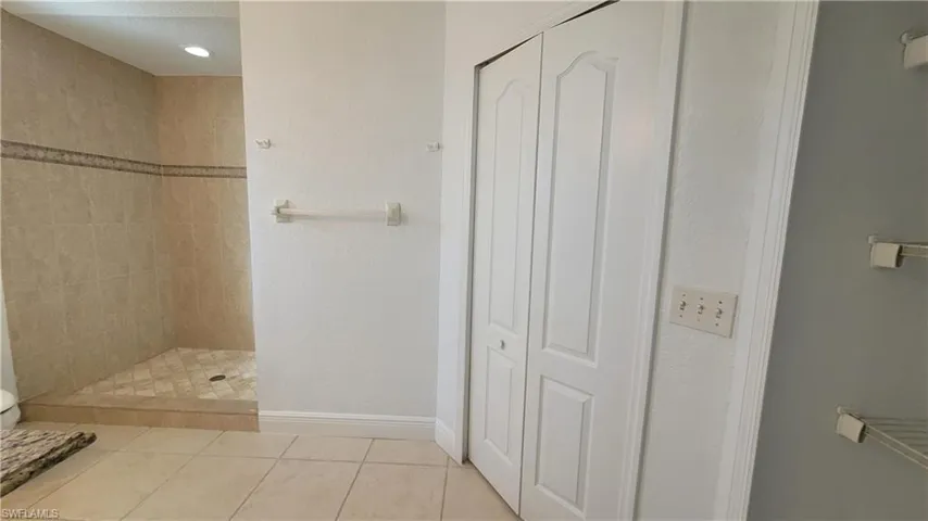 Bathroom featuring tile patterned floors and tiled shower