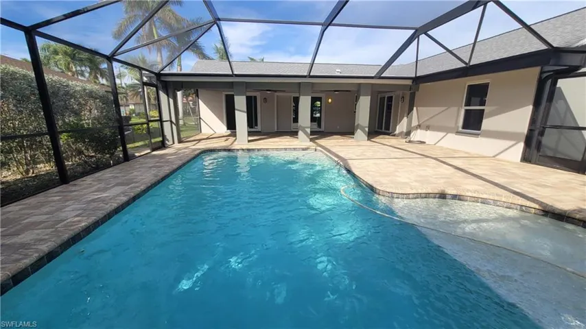 View of swimming pool with ceiling fan, a lanai, and a patio