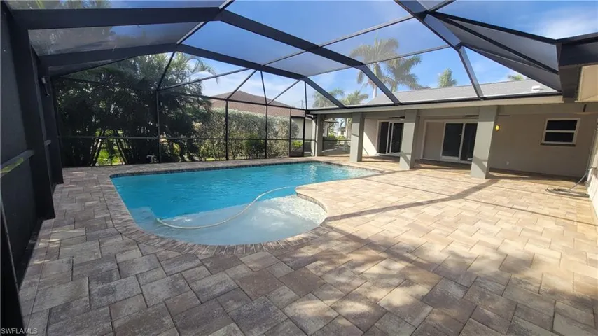 View of pool with ceiling fan, a lanai, and a patio