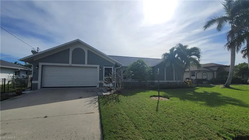 Ranch-style home with a front lawn and a garage
