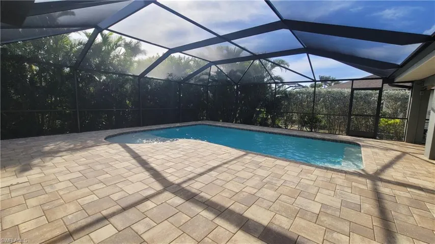 View of swimming pool with a lanai and a patio