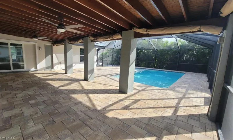 View of swimming pool with a lanai, a patio area, and ceiling fan