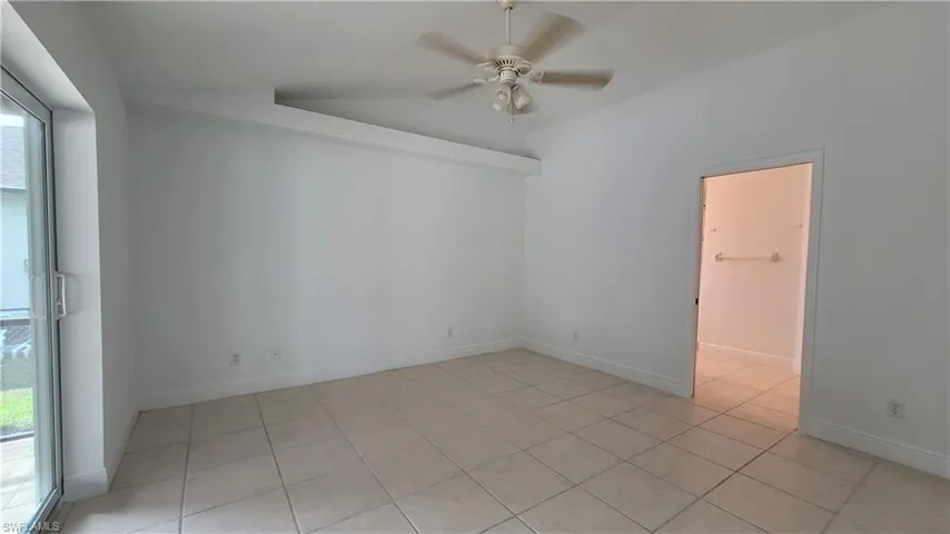 Spare room with ceiling fan, a healthy amount of sunlight, and light tile patterned floors