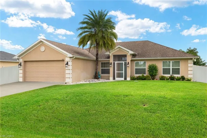 Single story home with a front yard and a garage