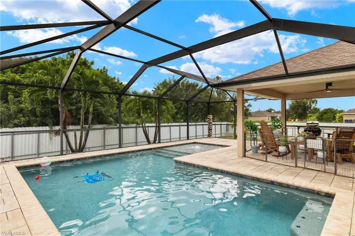 View of pool with glass enclosure and a patio area