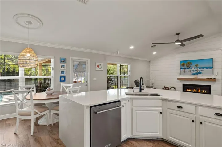 Kitchen with light hardwood / wood-style flooring, sink, ceiling fan, lofted ceiling, and stainless steel dishwasher